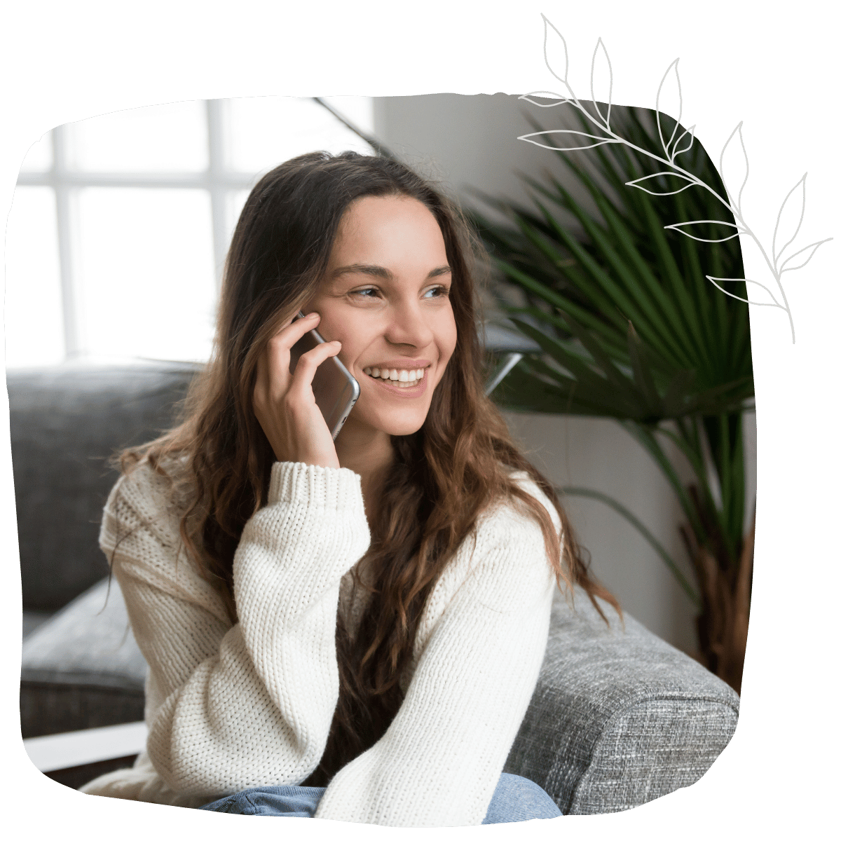 A woman smiling while talking to her phone to contact Maela Support Services