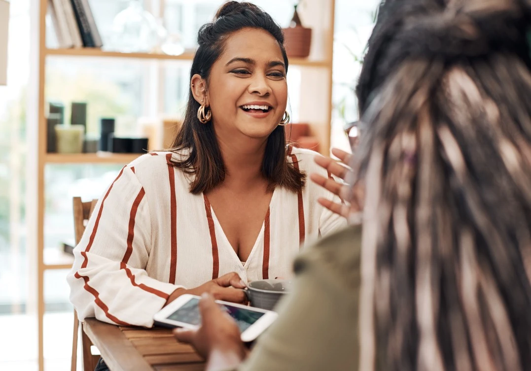 A woman smiling while talking to her friend