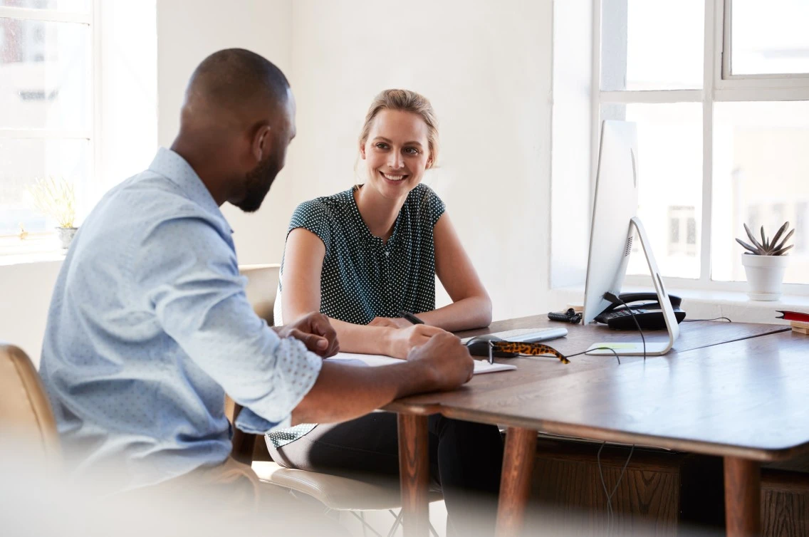 A man and a woman smiling while talking